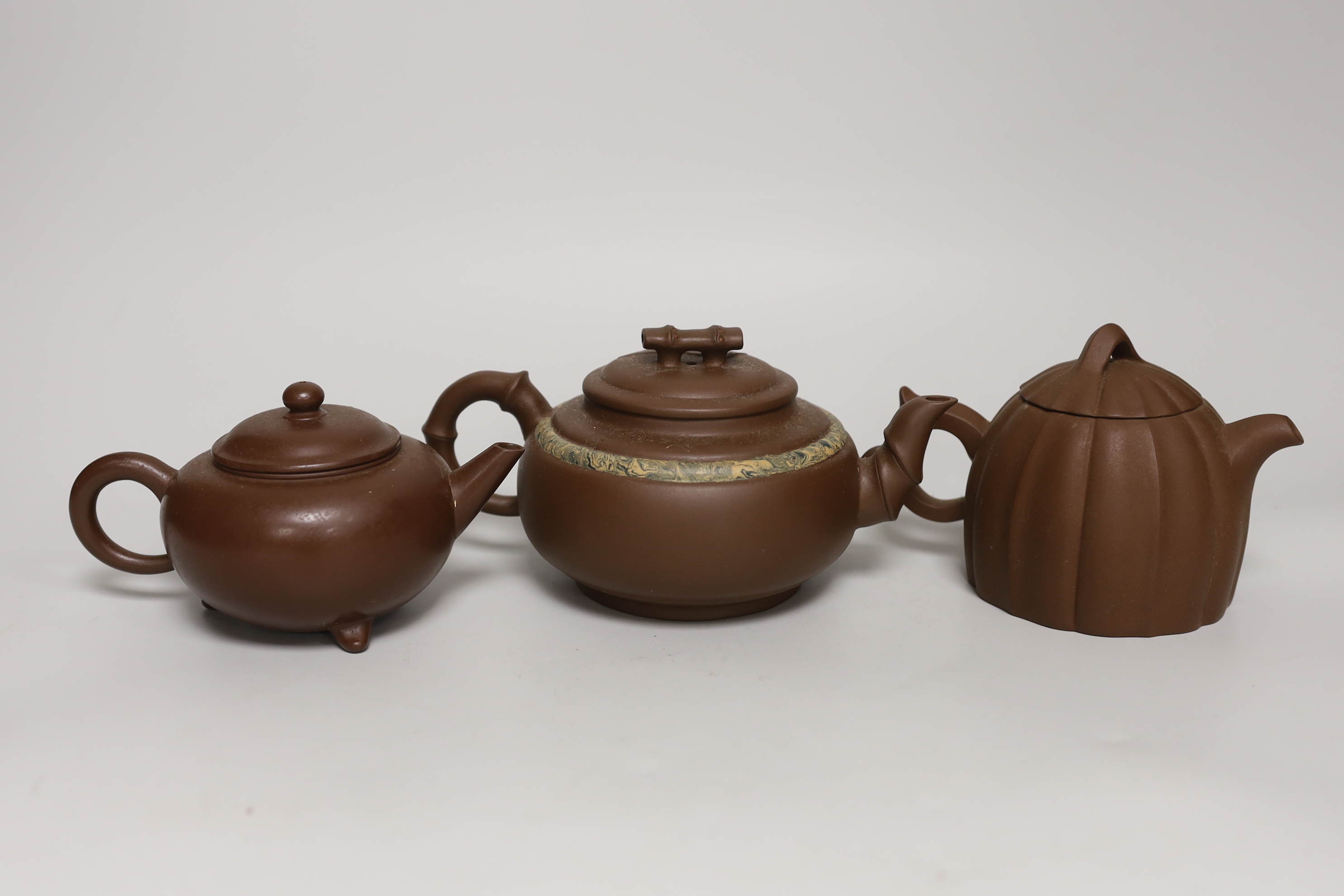 Three Chinese Yixing dark brown zisha clay teapots, one with marbled clay band largest 12cm diam.